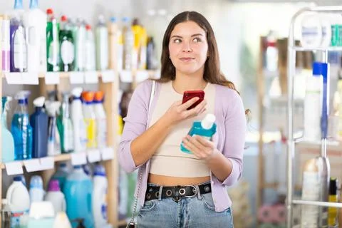 Checking expiration date of liquid hand soap - female shopper scans QR code on Stock Photos