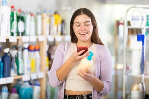 Checking expiration date of liquid hand soap - female shopper scans QR code on Stock-Fotos