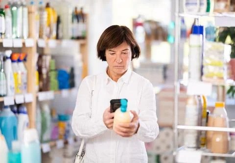 Checking expiration date of liquid hand soap - female shopper scans QR code on Stock-Fotos