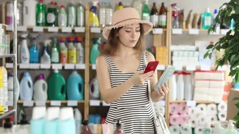 Checking expiration date of tanning product or sunscreen - female shopper scans Stock Footage 341378595