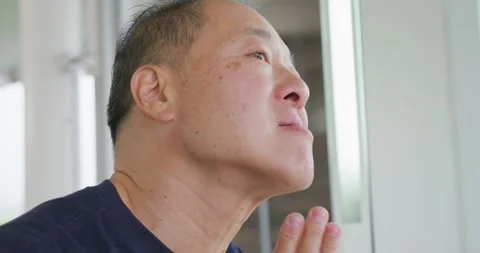 Checking face at bathroom mirror, Senior Asian man pressing, rubbing cheek and Stock Footage 337730774