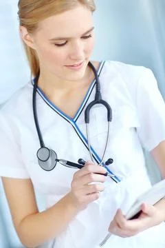 Checking the files. a nurse writing notes in her notepad. Stock Photos