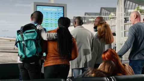 Checking flight status information, screen and diverse tourists with trolleys Video stock 333653059