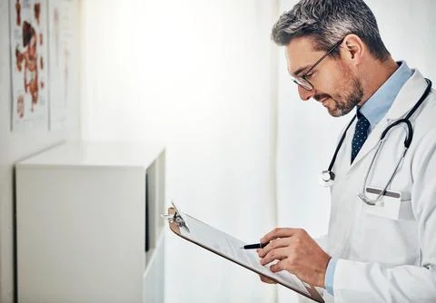 Checking up on his patients progress. a focussed doctor reading a patient file Foto stock