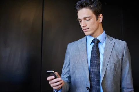 Checking his work calender. Shot of a handsome young businessman in a suit using Stock Photos