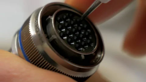 Checking the holes of huge Circular Connector. Electronic Components. Close up Stock Footage 197344240