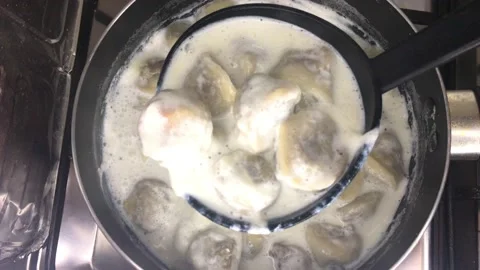 Checking home made Shishbarak in a pan on fire Stock Footage 166404542