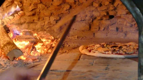 Checking if pizza is ready in wood fired oven, traditional, rustic cuisine 스톡 동영상 77375724