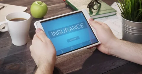 Checking insurance info using digital tablet at desk Stock Footage