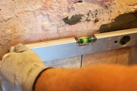 Checking the level of ceramic tiles close up Stock Photos