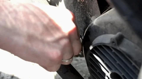 Checking the level of engine oil in a motorcycle, a man unscrews the valve Stock Footage 112427369