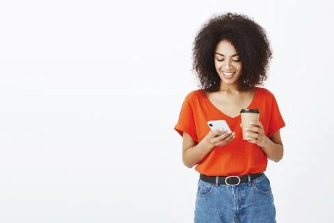 Checking mailbox while standing in queue. Modern attractive curly-haired african Foto stock