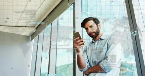 Checking man in blue shirt, rolled-sleeves holding phone by glass, viewing data Stock Photos