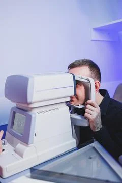 Checking a man's vision with a modern microscope at an appointment with an .. Foto stock