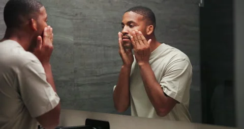 Checking, mirror and skincare with black man in bathroom of home for morning Stock Footage 337452057