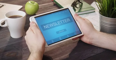 Checking newsletter landing page using tablet computer at desk 動画素材 80721755