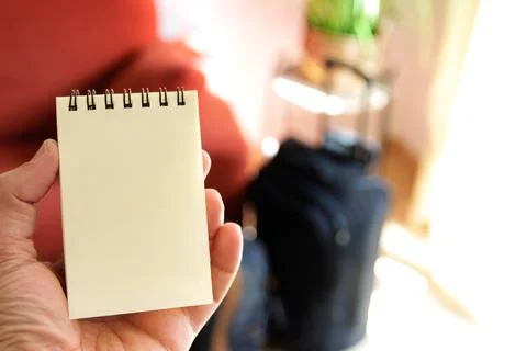 Checking in a notebook what we have put in the travel suitcase Stock Photos