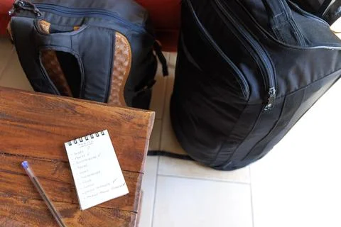 Checking in a notebook what we have put in the travel suitcase Stock Photos