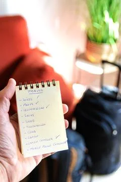 Checking in a notebook what we have put in the travel suitcase Stock Photos