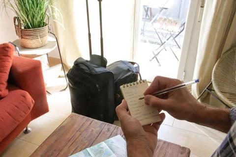 Checking in a notebook what we have put in the travel suitcase Stock Photos