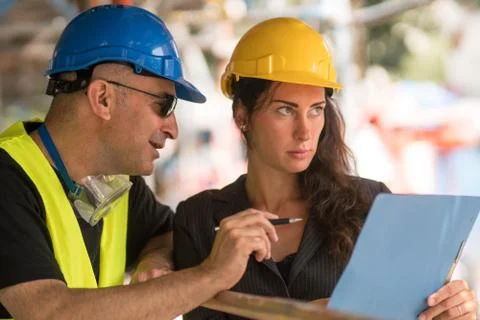 Checking office blueprints on construction site Stock Photos
