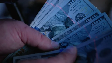 Checking one hundred dollar bills with ultraviolet lamp. Fraud crime. Stock Footage 169017789