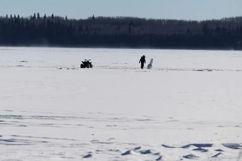 Checking Out a Lonely Snowman in the Middle of a Frozen Lake Stock Photos