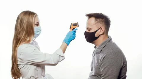 Checking patient body temperature test using a non-contact thermometer nurse Stock Photos