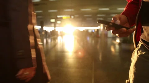 Checking phone with airport sunset in background Stock Footage 25601321