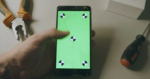 Checking phone with broken screen, smartphone with green screen and scrolling Video stock 93324068