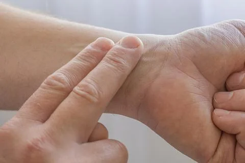 Checking Pulse On Wrist With Fingers Foto stock