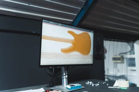 Checking the quality of a guitar on the computer screen, working in the guitar Foto stock