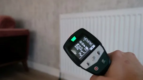 Checking Radiator Temperature with Infrared Thermometer in Living Room with Sofa Stock Footage 304381285