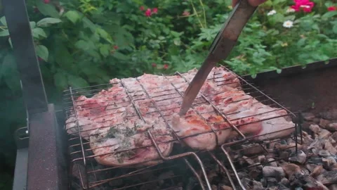 Checking the readiness of chicken with knife over the burning coals in grill Stock Footage 157630685