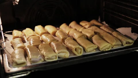Checking the Readiness of Meat Crepe Rolls Inside a Hot Oven Stock Footage 332159792