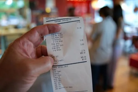 Checking the restaurant receipt for accuracy with young women customers in th Stock Photos
