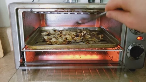 Checking roasting or broiling thin slices of onion mix with olive oil 스톡 동영상 102985800