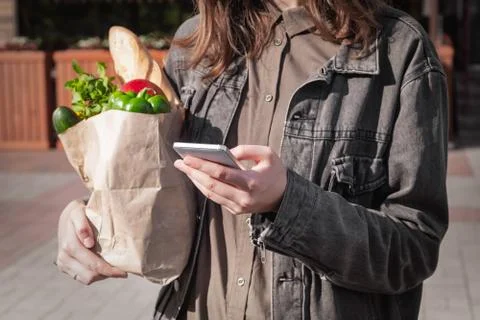 Checking shopping list in smarphone while shopping for food.  Stock Photos