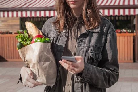 Checking shopping list in smarphone while shopping for food.  Stock Photos