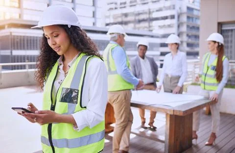 Checking site updates. an attractive young female construction worker using a Foto stock