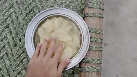 Checking sliced potatoes soaking in water bowl Stock Footage 347628385