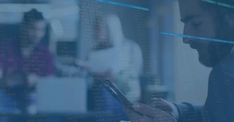 Checking smartphone, bearded man in blazer looking down in office with code Foto stock