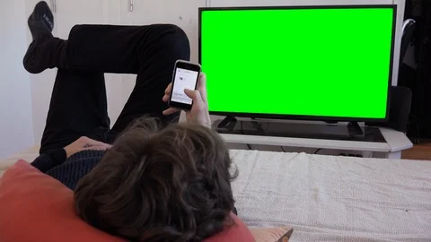 Checking Smartphone Emails Watching TV Green Screen Television Stock Footage 102382176