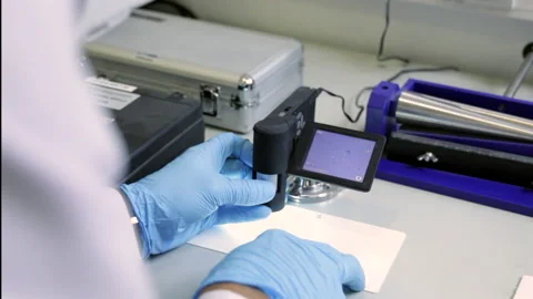 Checking some samples on plastic board with a modern microscope. Stock Footage 141761504