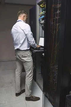 Checking on the status of his repairs. Rearview shot of a mature man using a 写真素材