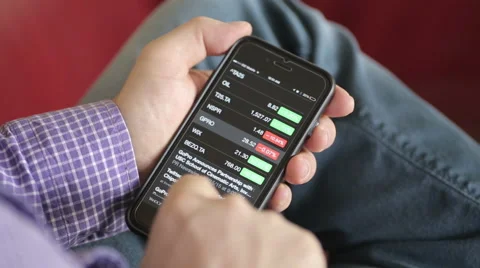 Checking stock quotes on mobile phone Stock Footage 56050543