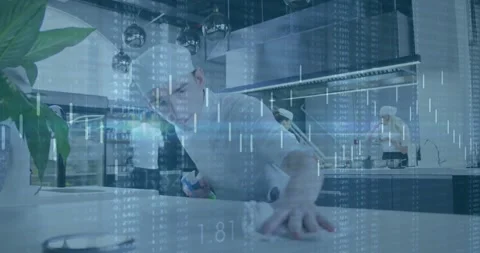 Checking surface, chef in white jacket near island spraying bottle and wiping Stock Footage 331593315