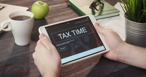 Checking tax time web page using digital tablet at desk Stockbeeldmateriaal 80738153