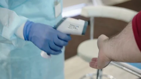Checking the temperature with a non-contact thermometer. A nurse in gloves Stock Footage 195120486