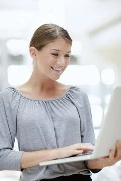 Checking their corporate progress online. A beautiful young woman using her Foto stock